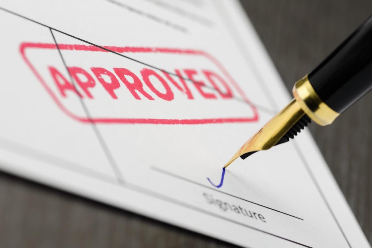 Papel de firma de pluma que confirma que alguien será aprobado para una hipoteca